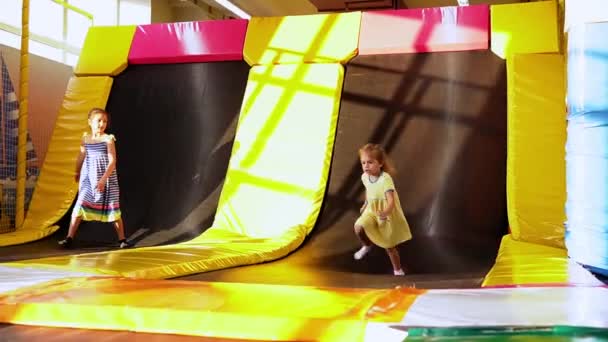 Happy Cute Little Przedszkola Tinaiger Dziewczyny rządzące radośnie w pokoju zabaw. Dzieci wskakują na trampoliny w Kids Entertainment Center. Bawcie się dobrze na placu zabaw. Dzieciństwo, Rozwój, Koncepcja czasu wolnego — Wideo stockowe