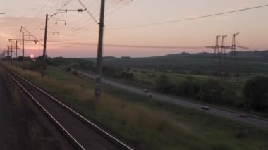 Yüksek hızlı trenden manzarası olan doğa yolu manzarası akşam gökyüzünde arabasıyla yaz arkaplanında gün batımı. Kırmızı batan güneş ufukta. Ulaşım, seyahat, demiryolu, iletişim konsepti