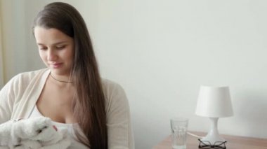 Sevimli Hamile Kadın Doğum Hastanesi için Toplanma Listesi Hazırlık Çantası Yazıyor. Hamilelikteki genç Ledy evde sarı gri koltukta eğleniyor. Annelik, Sağlık Hizmetleri Konsepti