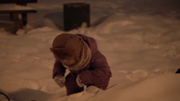 Invierno, vacaciones, juegos, conceptos familiares: plan intermedio de auténticos niños pequeños preescolares felices Los niños se divierten en el parque nocturno, esculpiendo bolas de nieve caen en la zona de nieve en clima frío y helado — Vídeo de stock