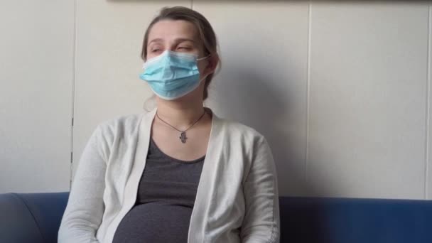 Młoda Kobieta Ciąży Medycynie Maska Ochronna Czytanie Kanapie Czeka Powołanie — Wideo stockowe