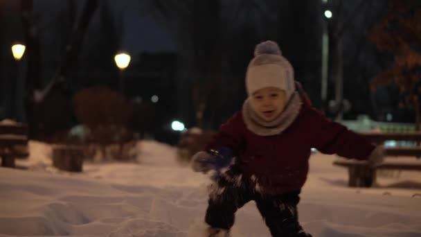 Invierno, vacaciones, juegos, conceptos familiares: plan intermedio de auténticos niños pequeños preescolares felices Los niños se divierten en el parque nocturno, esculpiendo bolas de nieve caen en la zona de nieve en clima frío y helado — Vídeos de Stock