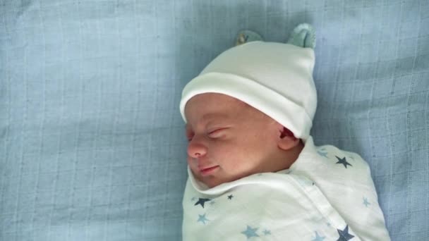 Pasgeboren baby gezicht portret acne allergische irritaties vroege dagen slapen op blauwe achtergrond. Kind aan het begin Minuten van het leven op hoed. Zuigelingen, Bevalling, Eerste momenten van Borning, Beginnen Concept — Stockvideo