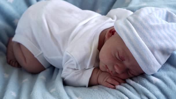 Primer plano recién nacido bebé cara retrato primeros días durmiendo dulcemente en la panza azul estrella fondo. Niño al principio Minutos de la vida en sombrero. Bebés, Parto, Primeros Momentos Del Nacimiento, Principio Concepto — Vídeo de stock