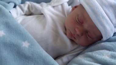 Makro Uyku ve Mavi Yıldız Arkaplanda Açık Gözler 'de Yeni Doğmuş Bebek Yüzü İlk Günler Portresi. Hayatın başlangıcındaki çocuk şapkayla. Bebekler, Doğum, Doğumun İlk Anları, Başlangıç Konsepti