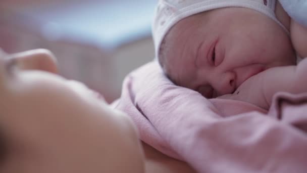 特写面对新生儿出生后在妈妈的胸部裸露的脸分娩后。母亲在医院分娩后抚养婴儿。妈妈生了个男孩儿父母和婴儿分娩的第一时间 — 图库视频影像