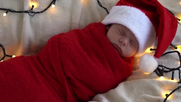 更新：2009-5-13阅读：在白色的花园背景下,穿着红尿布的圣诞老人宝宝睡觉时,刚出生的可爱可爱的小宝宝。圣诞快乐，新年快乐，婴儿，童年，冬天的概念 — 图库视频影像