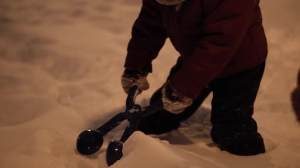 冬天，假期，游戏，家庭观念- -孩子们在晚上公园里玩得开心，在寒冷的天气里，雪球在雪地上飘扬的中间计划 — 图库视频影像