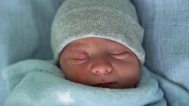 Retrato de la cara del bebé recién nacido Irritaciones alérgicas al acné Primeros días durmiendo sobre fondo azul. Niño al principio Minutos de la vida en sombrero. Bebés, Parto, Primeros Momentos Del Nacimiento, Principio Concepto — Vídeo de stock