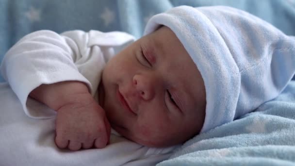 Retrato de la cara del bebé recién nacido Primeros días en Macro Despertar y abrir los ojos en el fondo de la estrella azul. Niño al principio Minutos de vida en el sombrero. Bebés, Parto, Primeros Momentos Del Nacimiento, Principio Concepto — Vídeo de stock