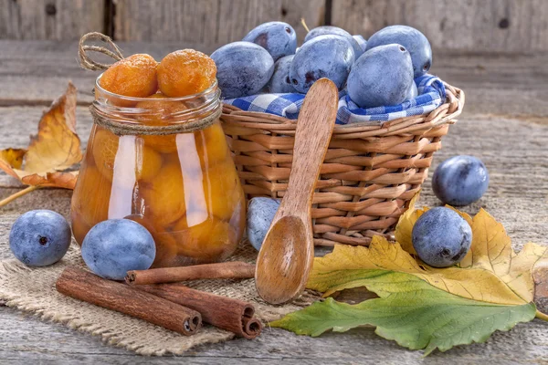 Fresh and canned plums on table — Stock Photo, Image