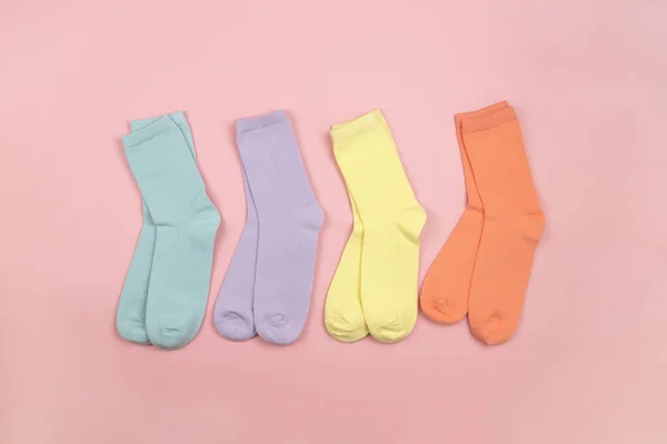 Renkli çocuk çorapları, desensiz, mavi, eflatun, sarı, pembe arkaplanlı turuncu, metin, kopyalama alanı, düz, minimal stil. Çocuk kıyafetleri, ev idaresi..