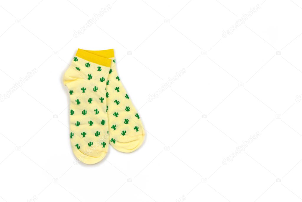 Funny womens or mens, unisex, cropped yellow socks with green cacti isolated on white background, copy space, flat lay. Fashion concept, unusual, trendy clothes, humor. Top view, place for text.