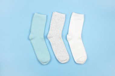 Şablonu olmayan renkli çocuk çorapları, mavi, gri, mavi arka planda beyaz, kopya alanı olan, düz, minimal tarzda. Konsept giysiler, oda servisi, sıralama, azaltma, düzenleme.