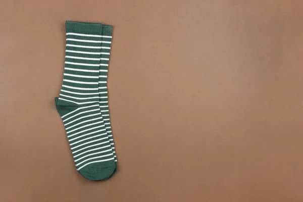 茶色の背景に緑の縞模様の靴下のペア フラットで最小限のスタイル トップビュー コピースペース 男性の服をコンセプトに ハウスキーピング ソート 水平形式 — ストック写真