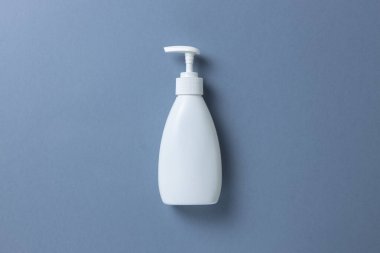 El sabunu, duş jeli ya da gri arka planda vücut kremi olan beyaz bir şişe. Mesaj ya da fotokopi için bir yer bul. Kişisel temizlik, cilt bakımı konsepti. Yatay olarak. Asgari düzeyde. Düz yatış, üst görünüm.