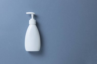 El sabunu, duş jeli ya da gri arka planda vücut kremi olan beyaz bir şişe. Mesaj ya da fotokopi için bir yer bul. Kişisel temizlik, cilt bakımı konsepti. Yatay olarak. Asgari düzeyde. Düz yatış, üst görünüm.
