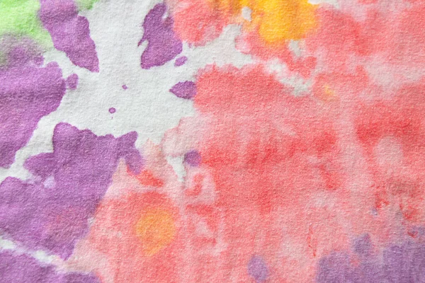 Pastel tie dye, a handmade pattern on a cotton t-shirt. Close-up, top view. DIY concept, handicrafts, original everyday clothes, fabric dyeing techniques. Flat lay, horizontal. Abstract background.