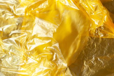 Arka plan, sarı geri dönüşümlü polietilen dokusu. Eko, sıfır atık, plastik konsepte alternatif. Düz yatıyordu. Yatay olarak. Yakın plan. Eko günlüğü için.