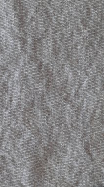 Kırışık keten kumaş arka planının en üst görüntüsü. Çay havlusu, peçete, masa örtüsü ya da giysi yakın plan. Basitlik kavramı, çevre dostluğu, doğal giysiler, ev yapımı tekstil. Dikey.