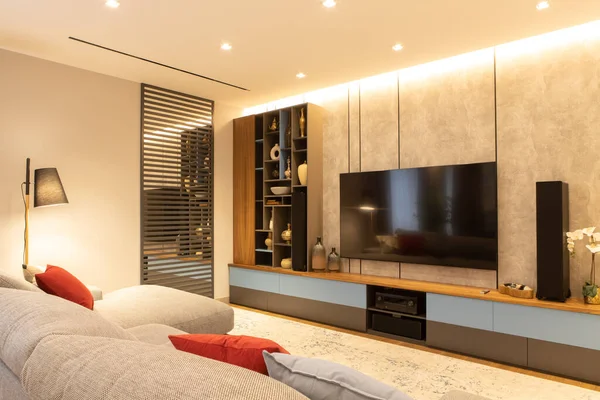 Modern oturma odasının içinde kanepe, kanepe, televizyon ve açık depolama sistemi var. Kavram, minimalist tarzda modaya uygun iç mekan, doğal malzemeler tarafsız tonlarda, evde dinlenmek için yer..