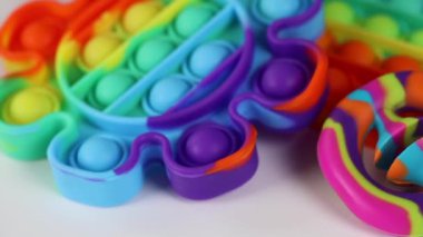 Stres önleyici oyuncaklar, basit gamzeler, beyaz arka planda dönen snapperlar. Kıpır kıpır çocuklar için konsept eğlence, hassas motor becerilerin gelişimi için duyusal oyuncaklar, stres giderici.