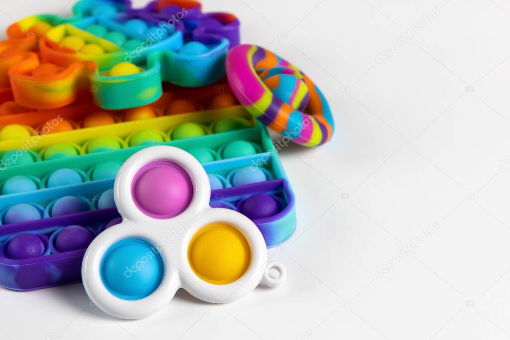 Anti-stress toys pop it, simple dimple, snappers on white background, copy space. Concept trendy entertainment for fidget children, sensory toys for development of fine motor skills, stress relieving.