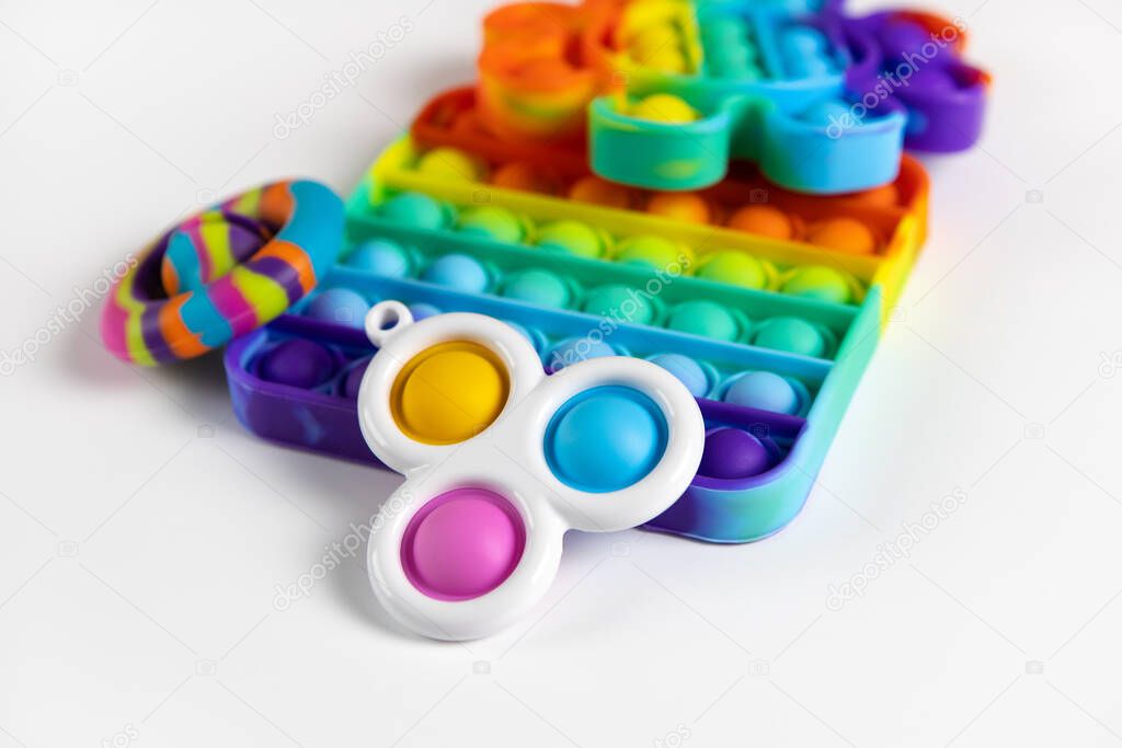 Anti-stress toys pop it, simple dimple, snapperz on white background, copy space. Concept trendy entertainment for fidget children, sensory toys for development of fine motor skills, stress relieving.