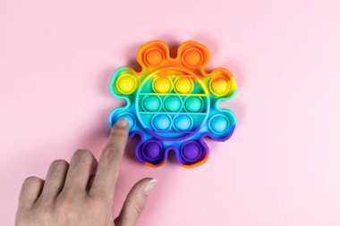 Gençler stres önleyici oyuncaklarla oynarlar. Pastel pembe arka plana koyarlar, fotokopi çekerler. Kıpır kıpır çocuklar için konsept eğlence, hassas motor becerilerin gelişimi için duyusal oyuncaklar, stres giderici.