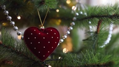 Modaya uygun ve modaya uygun kadife bir Noel oyuncağı. Arka planda sıcak çelenk ışıkları hızla yanıp sönüyor. Yumuşak seçici odaklanma. Bokeh 'in şenlik geçmişi. Yeni yıl konsepti. Boşluğu kopyala.