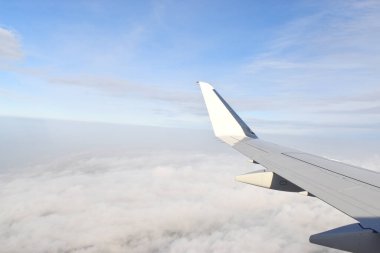 Güzel beyaz bulutlar yüksek açılı havada süzülüyor, uçak penceresinden görülüyor..