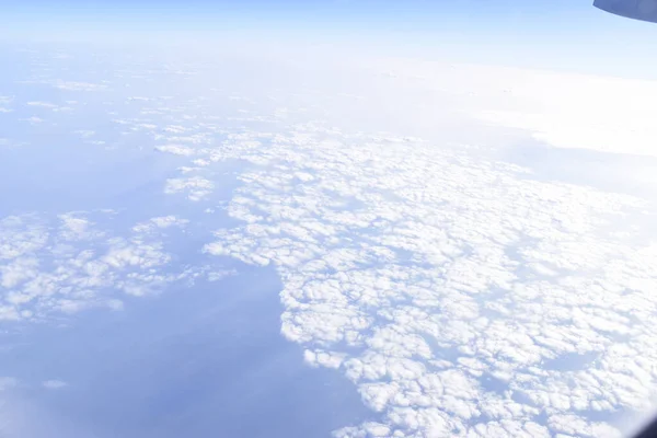 곳에서 내려다 보이는 구름이 하늘을 배경으로 있었다 비행기 창문으로 — 스톡 사진