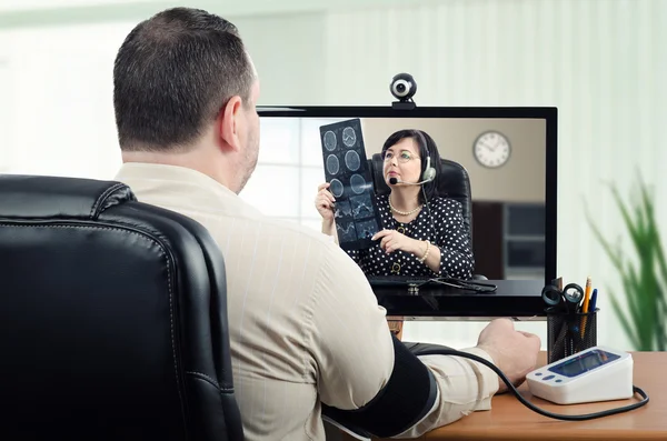 Man measures his blood pressure under virtual doctor control — Stock Photo, Image