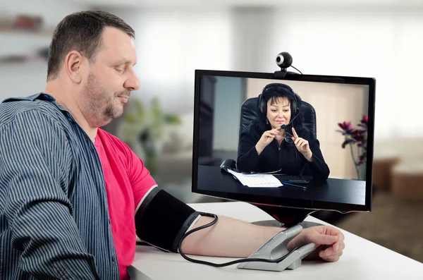 Man having her blood pressure checked by virtual physician — Stock Photo, Image