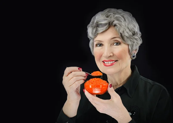 Espectacular mujer mayor comiendo caviar rojo — Foto de Stock