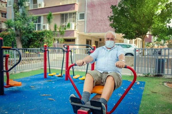 Seniors Dans Masque Facial Fonctionne Sur Une Machine Ramer Assis — Photo