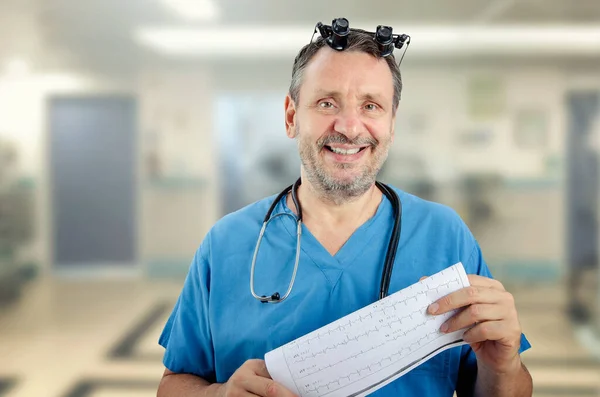 Uśmiechnięty Lekarz Szpitalnym Mundurze Patrzy Kamerę Brodaty Mężczyzna Trzyma Wydrukowane — Zdjęcie stockowe