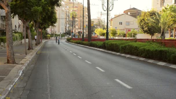 Hijo y padre en bicicleta en ciudad desierta — Vídeo de stock