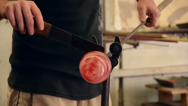 Glassmaker twirls red glass ball — Stock Video