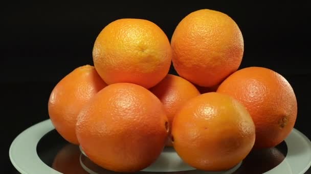 Апельсины на вращающейся пластине — стоковое видео