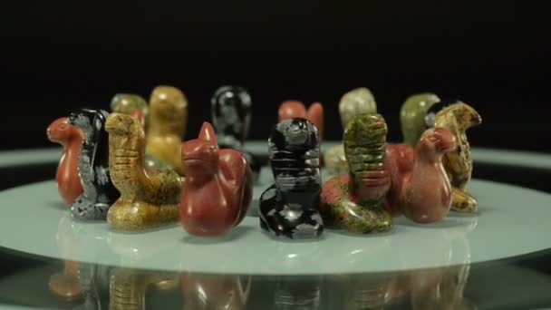 Statuette serpenti ruotano su lastra di vetro — Video Stock