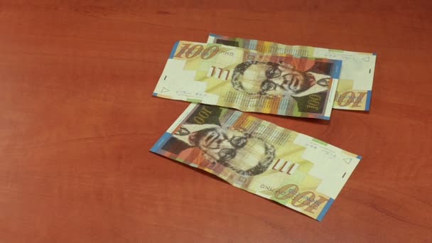 Espalhando contas shekel israelenses na mesa de madeira — Vídeo de Stock