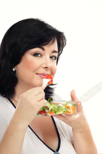 Mulher de cabelos pretos está comendo salada de legumes saudável — Fotografia de Stock