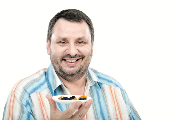 Smiling guy likes dried fruits — 스톡 사진