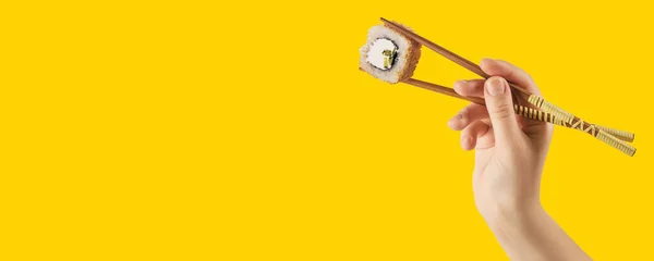 Vrouwenhanden Houden Sushi Broodjes Met Stokken Vast Gele Achtergrond Creatief — Stockfoto