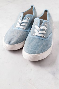 high angle view of blue fabric sneakers on grey textured background