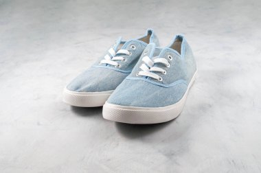 Gri desenli arka planda mavi kumaş tarzı ayakkabıların yan görünümü