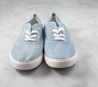 Gri desenli arka planda mavi kumaş tarzı ayakkabılar.