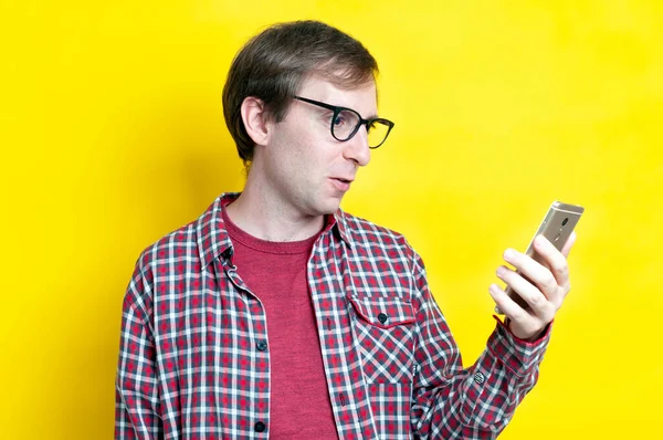 Guapo Hombre Sorprendido Rojo Camisa Cuadros Gafas Mirando Teléfono Inteligente — Foto de Stock