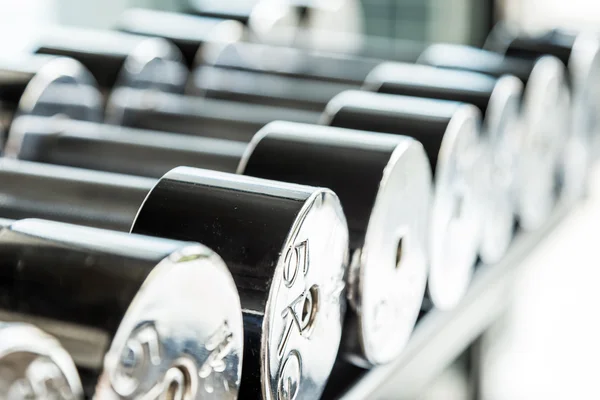 Dumbbells weight training equipment in gym close up
